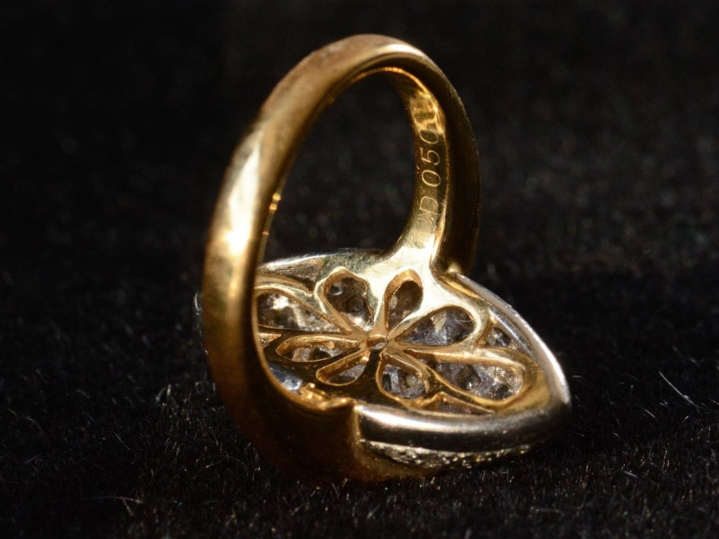 Inside of c1990 Diamond Egg Ring showing filigree design in yellow gold.  A hallmark stamped D050 is visible. Shown on black background.