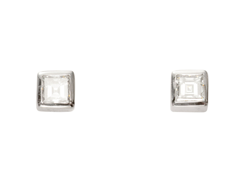 Pair of 0.19cttw square step cut white diamond stud earrings in platinum bezels, shown on white background.