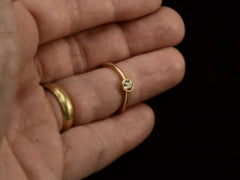 thumbnail of A simple EB Modern ring with a round light yellow diamond in a yellow gold bezel. Shown on hand for scale.