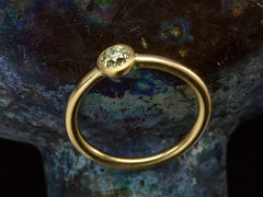 thumbnail of Angled profile view of simple EB Modern ring with a round light yellow diamond in a yellow gold bezel. Shown dark colorful background.