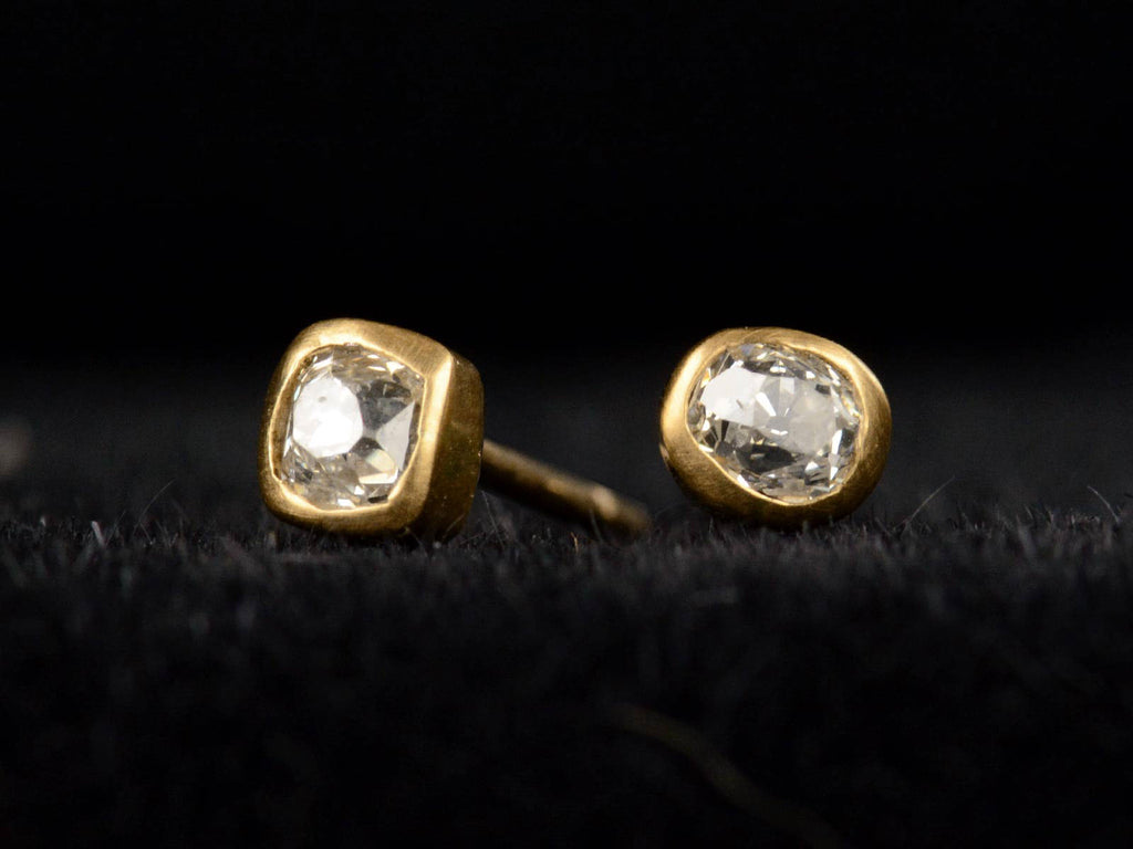 Angled front view of EB Stud Earrings with Old Mine Cut Diamonds Set in 22K Yellow Gold Bezels (shown on black background)