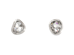 thumbnail of A pair of mismatched and irregular shaped rose cut diamonds set in platinum bezels as stud earrings, shown on white background