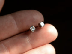 thumbnail of A pair of 0.52cttw Square Step Cut Diamonds Studs in Platinum Bezels (held in hand for scale)