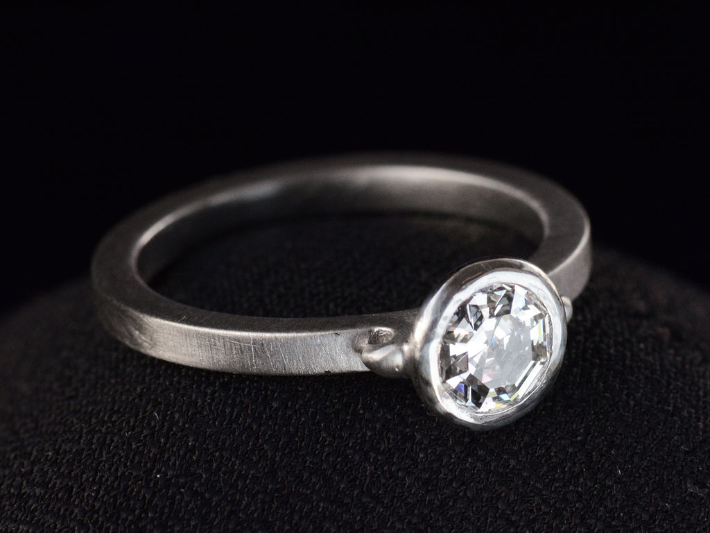 EB Round Step Cut Platinum Ring (left side angle view on dark background)