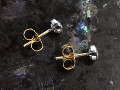 thumbnail of Side profile of EB Modern stud earrings with platinum bezels, round white old cut diamonds and 18K yellow gold posts and backs. Shown on dark background.