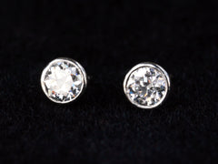 thumbnail of Detail view of EB Modern stud earrings with platinum bezels and round white old cut diamonds. Shown on black background.