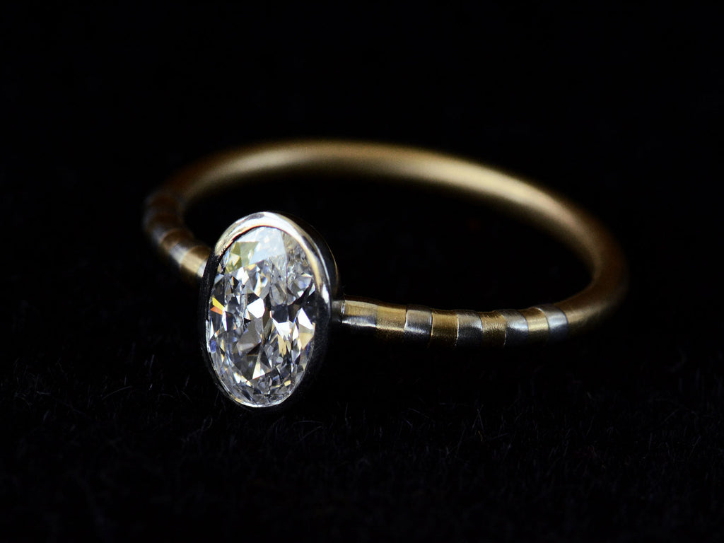 Right angled view of EB 0.69ct Oval Diamond Ring with Platinum Bezel and Striped Gold and Platinum Band (shown on dark background)