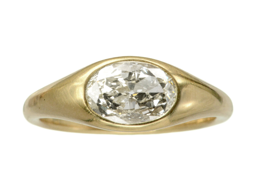 Flush set oval diamond ring in yellow gold, shown on white background.