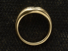 thumbnail of Side profile of flush set oval diamond ring in yellow gold, shown on dark background.