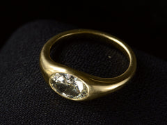 thumbnail of Elevated angled view of flush set oval diamond ring in yellow gold, shown on dark background.