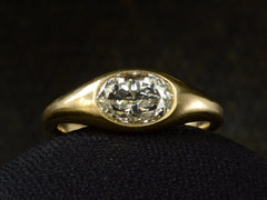 thumbnail of Flush set oval diamond ring in yellow gold, shown on dark background.