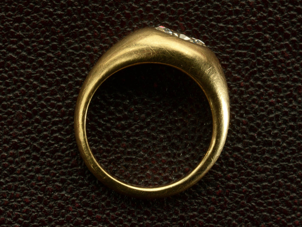 Side profile of EB Modern flush set oval white diamond in rounded 22K yellow gold setting, shown on dark background.