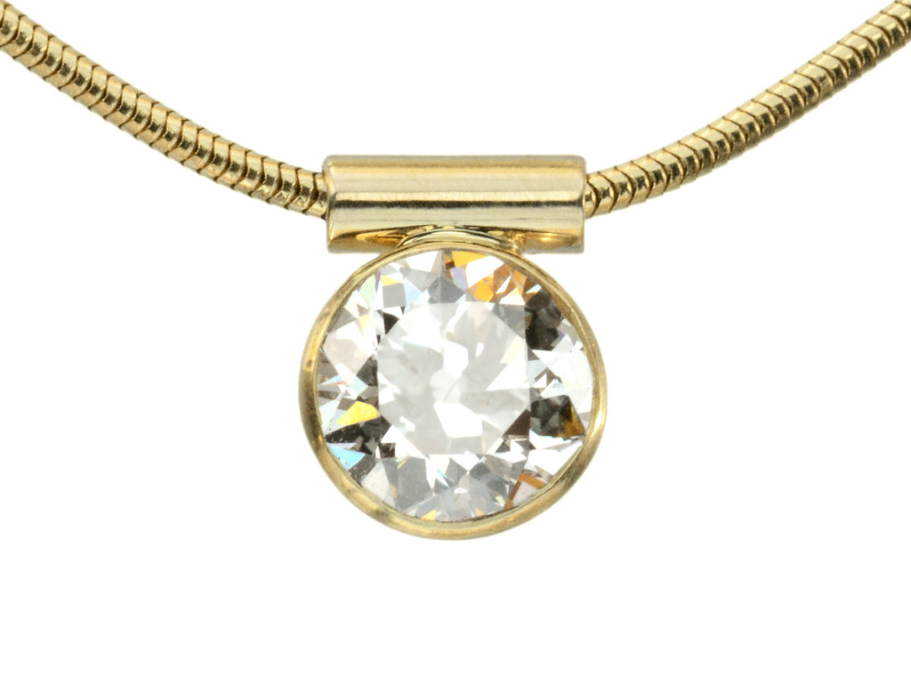 Detail of EB Modern necklace with a round old European cut diamond set in a yellow gold bezel on a yellow gold snake chain, shown on white background.