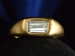 thumbnail of Face on view of EB Modern engagement ring with elongated emerald cut diamond flush set in a rounded 22k yellow gold mounting, on dark background.