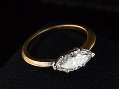 thumbnail of Detailed angled view of EB Modern engagement ring solitaire with marquise diamond set in platinum prongs with an 18K yellow gold knife edge shank, shown on dark background.