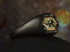 thumbnail of Left angled view of EB Modern hexagonal light yellow diamond set in yellow gold bezel sunken into pillowy blackened silver mounting (shown on dark background)