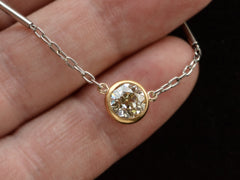 thumbnail of Detail of EB Modern necklace with round old cut diamond set in 22K yellow gold bezel on platinum chain. Shown held in hand.