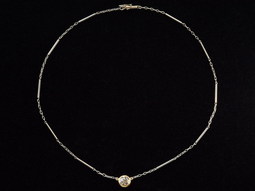 EB Modern necklace with old cut round diamond shown in 22k yellow gold bezel  on platinum chain. Shown on black background.