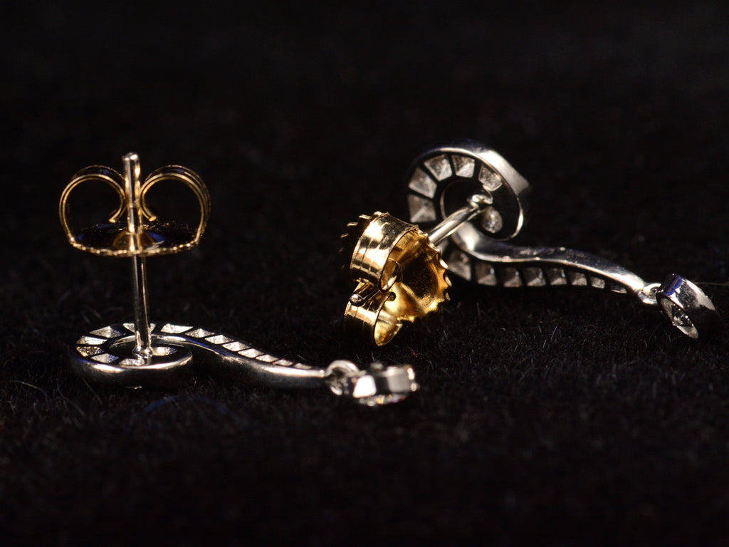 Reverse side view of EB Question Mark Stud Earrings with brilliant cut diamonds set in platinum, with 18K yellow backs. Shown on black background.