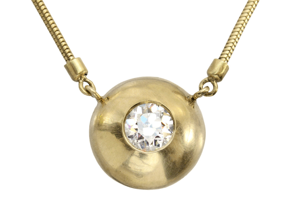 Detail view of EB Modern necklace with a domed yellow gold disk surrounding a round diamond. Shown on white background.