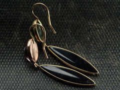 thumbnail of Reverse sides of a pair of earrings with mismatched tops of moss agate and pink foiled rock crystal and navette shaped onyx drops, shown on dark textured background.