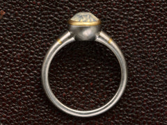 thumbnail of Side profile of a minimal platinum ring with an oval pale blue opalescent sapphire set in a yellow gold collar with additional yellow gold stripes on the shank. Shown on dark textured background.