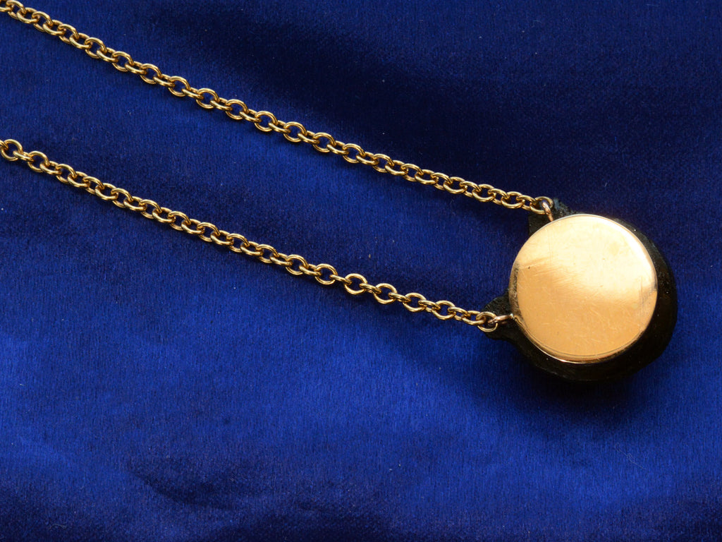 Backside profile of EB Black Glass Owl Pendant Necklace in Yellow Gold (detail on dark blue background)