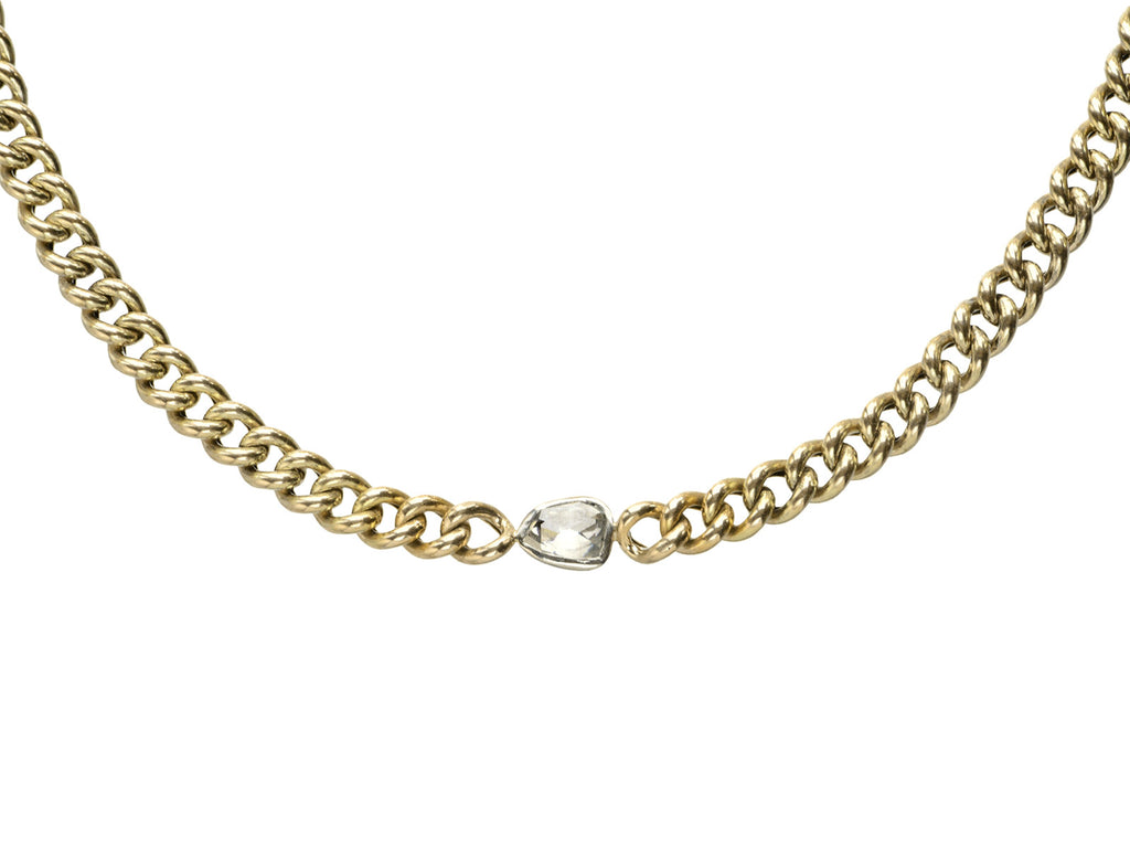 Detail of a curb link yellow gold chain necklace with a platinum bezel set rose cut diamond, shown on white background.