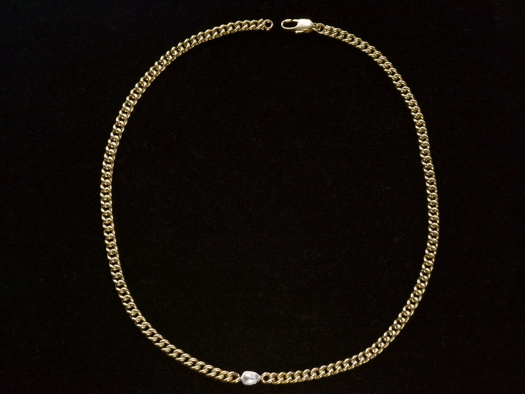 Curb link yellow gold chain necklace with a platinum bezel set rose cut diamond, shown on black background.