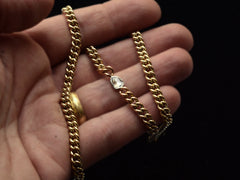 thumbnail of Curb link yellow gold chain necklace with a platinum bezel set rose cut diamond, shown on held on hand.