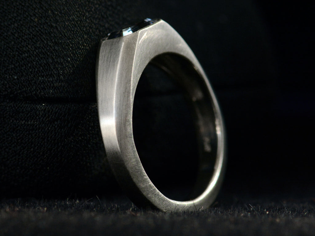 Angled side profile of EB Purple Spinel Signet Ring In Platinum (shown on black background)