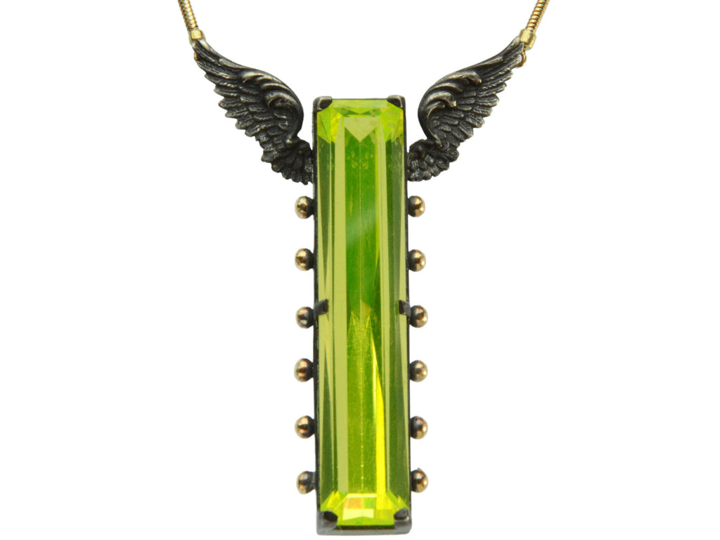 Detail of a pendant with a long florescent lime green uranium glass stone set in blackened silver with gold beads and wings on the mounting (on white background)