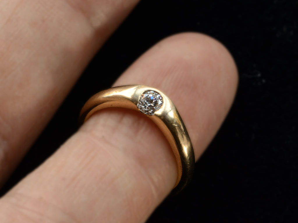 An arch-shaped vintage Tiffany & Co Elsa Peretti ring in yellow gold with a round white diamond, shown on finger