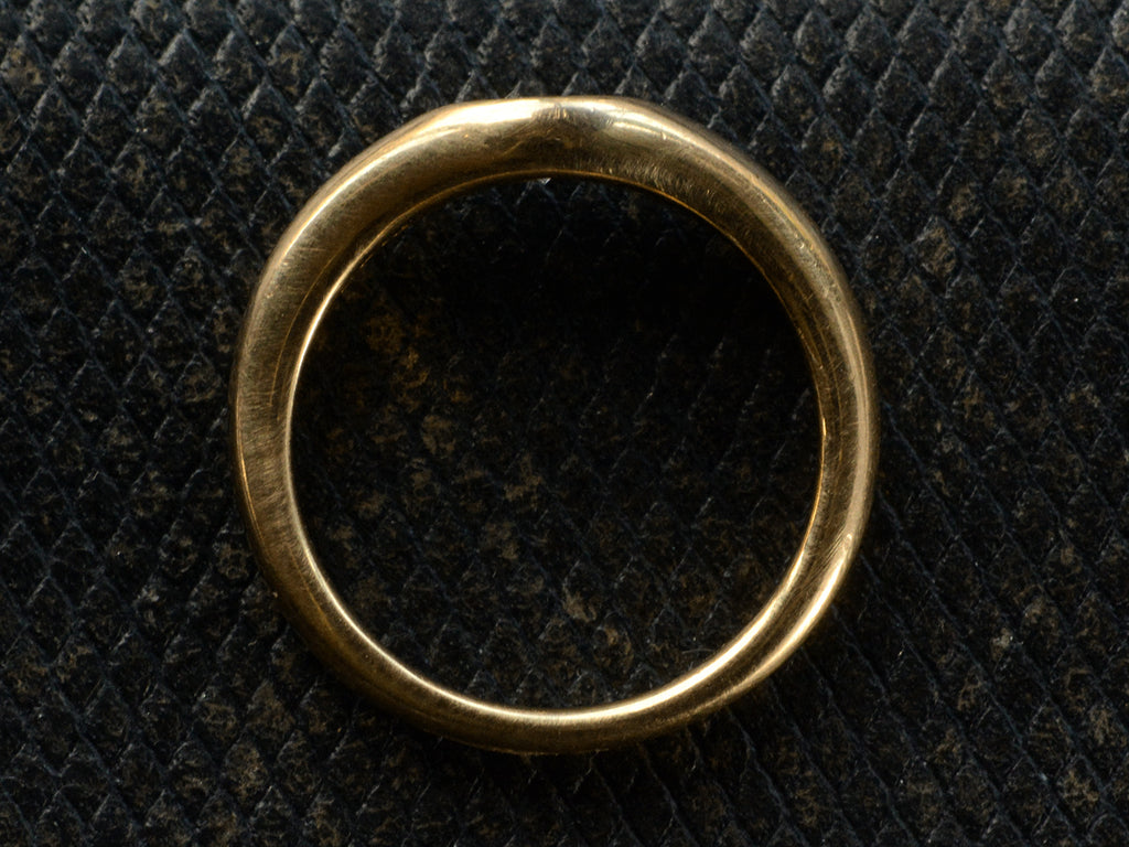 Side profile of vintage Tiffany & Co Elsa Peretti ring in yellow gold shown on dark textured leather background.
