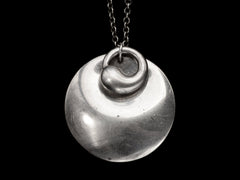 thumbnail of Pair of overlapping organic and minimal silver Elsa Peretti pendants, on black background. 