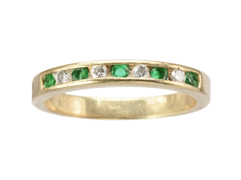 Vintage gold ring with alternating emeralds and diamonds on a white background