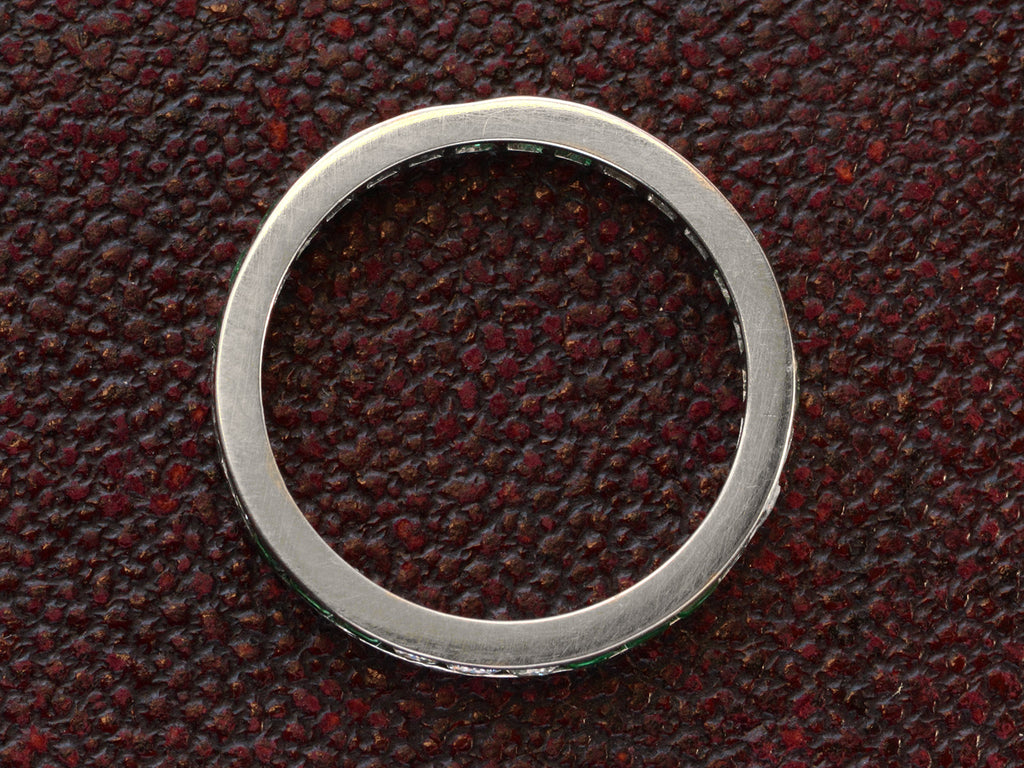 Side profile of vintage platinum eternity ring  on dark textured background.

