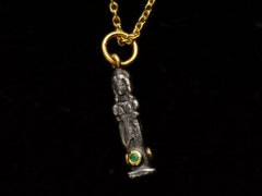 thumbnail of Face on angle of small three sided figural pendant in silver and 22K yellow gold with emeralds, shown on dark background.
