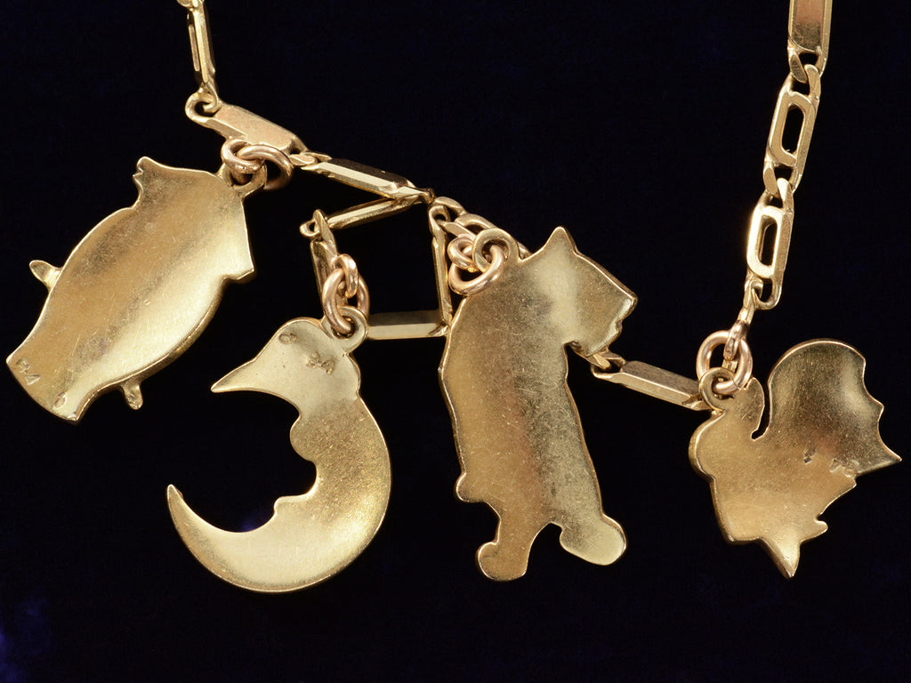 Reverse view of c1970 Enamel Charms Necklace (an owl, a moon, a tiger and a goldfish) in yellow gold. On a black background.