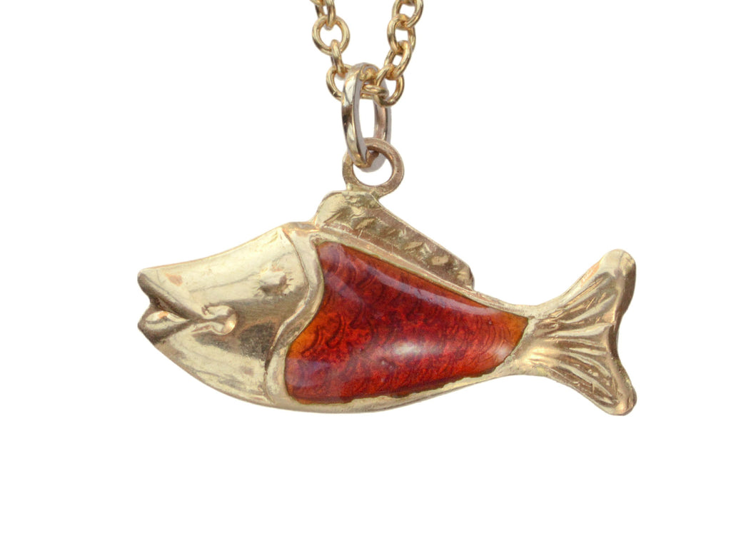 Vintage fish charm in yellow gold and orange enamel, shown on white background.