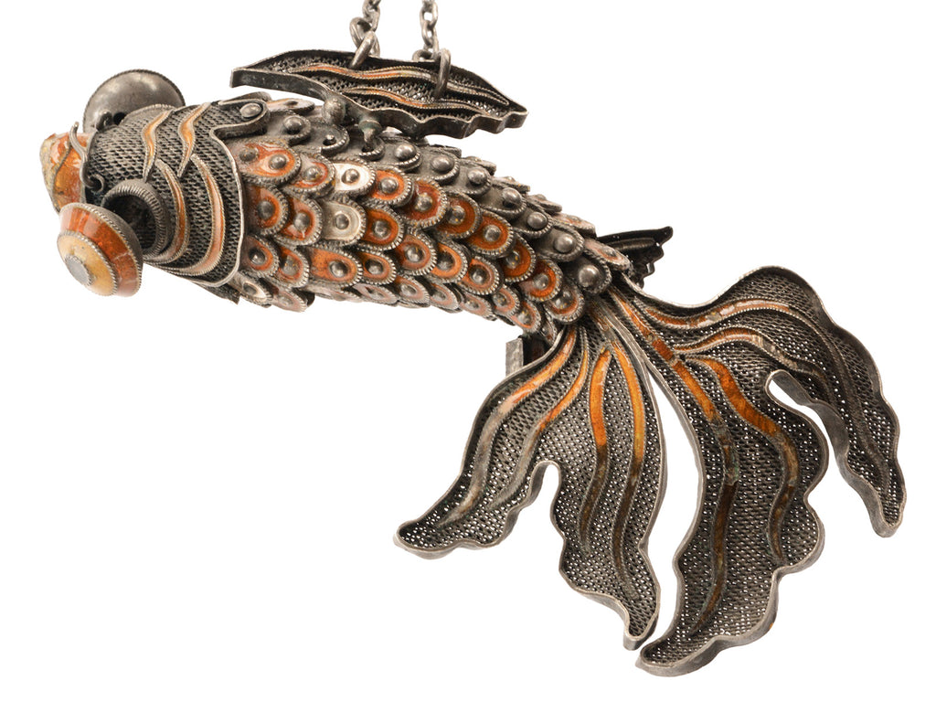 A vintage c1950 Chinese articulated fish pendant with orange enamel and filigree, shown on white background.