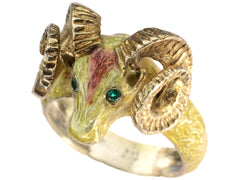 thumbnail of A c1960 vintage ram's head ring in yellow gold with green emerald eyes and yellow and orange enamel details. Shown on white background.