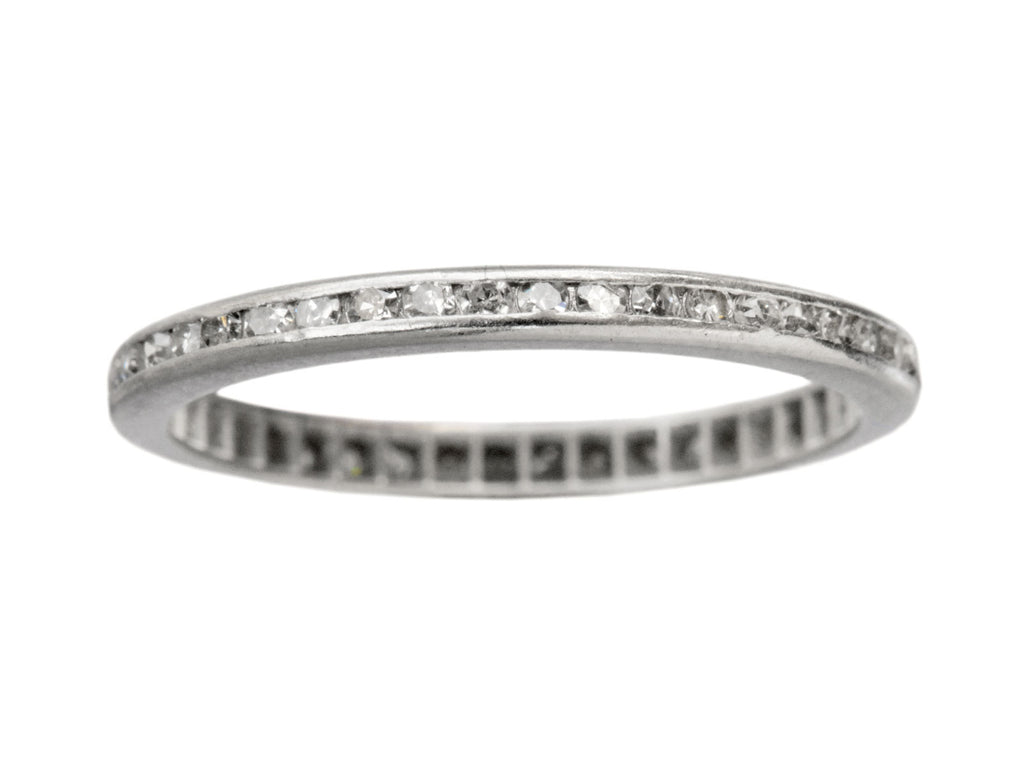 A thin vintage diamond eternity band in platinum, shown on white background.