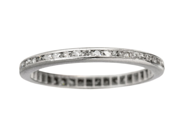 A thin vintage diamond eternity band in platinum, shown on white background.