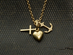 thumbnail of Vintage gold necklace with heart, anchor, and cross pendant on a textured dark background