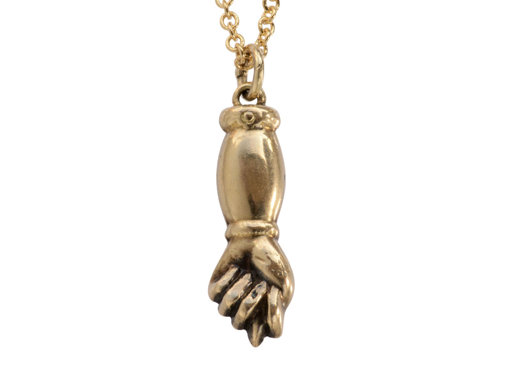 Vintage gold hand-shaped figa pendant on a chain against a white background