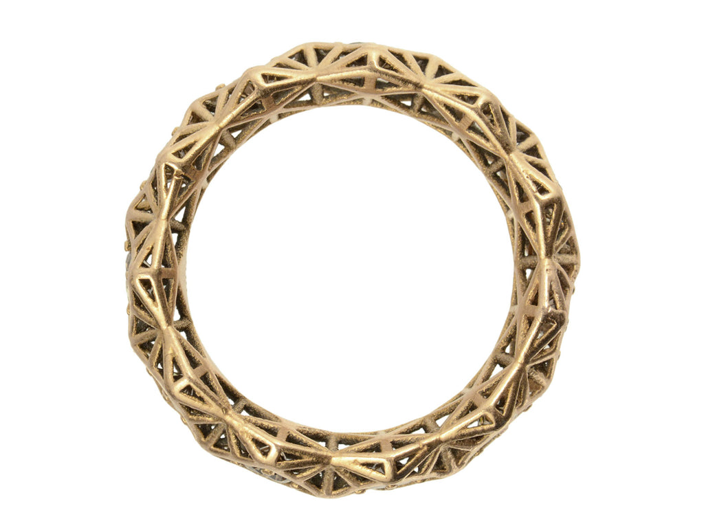 Side profile of rosy-yellow gold eternity band with geometric filigree. Shown on white background.