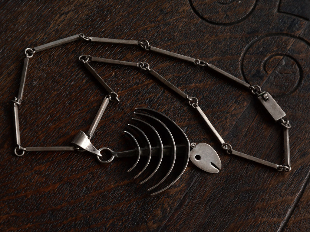 Detail of c1970 Silver Fish Skeleton Necklace (shown on dark wood background)