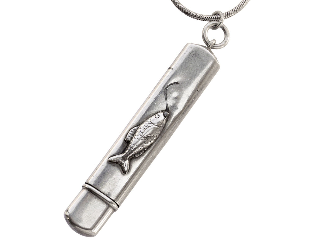 Detail of silver pendant with fish decoration, shown on white background.