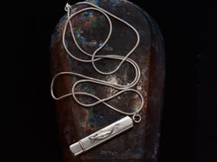 thumbnail of Silver pendant with fish decoration, shown with long silver snake chain on dark background.